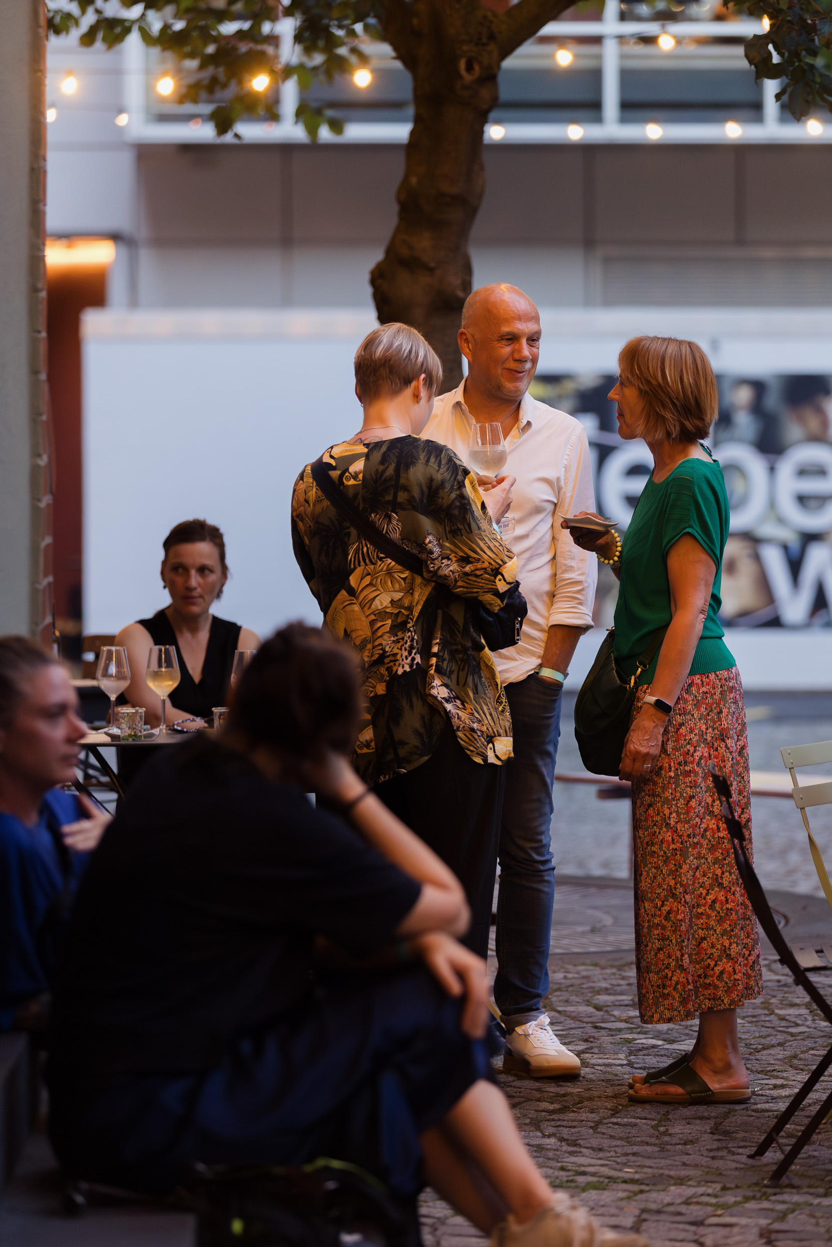 Impressionen vom Abend. Menschen stehen draußen und quatschen.